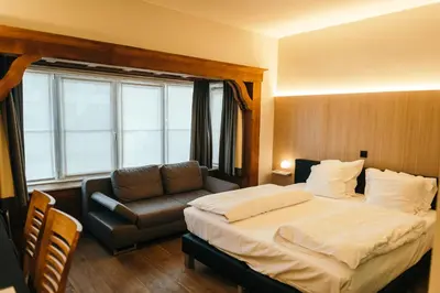 a hotel room with a bed and a couch at Guesthouse De Casteleer in Kasterlee
