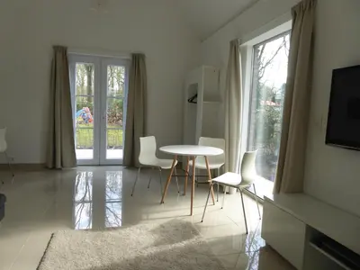 a living room with a table and chairs and a television at B&B Goudvink in Schilde