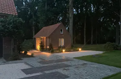 a house with lights in front of a driveway at B&B Goudvink in Schilde