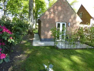 a brick house with a gate in a yard at B&B Goudvink in Schilde