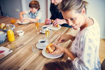 a woman sitting at a table eating a hamburger at De Schaapskooi in Kasterlee