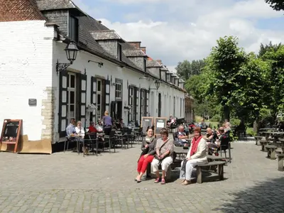 a group of people sitting on benches outside a building at B&B Wannes Suite in Leuven
