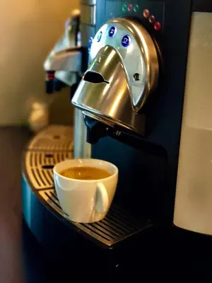 a cup of coffee sitting on a shelf next to a mixer at B&B Yellow Submarine in Antwerp