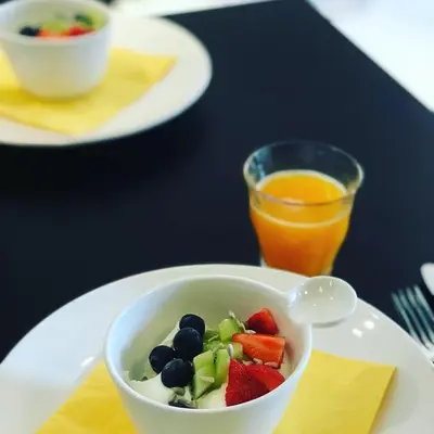 a bowl of fruit on a plate with an orange juice at B&B Yellow Submarine in Antwerp