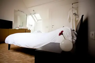 a bedroom with a white bed with a flower on it at B&B Yellow Submarine in Antwerp