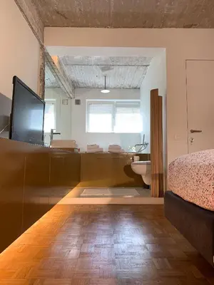 a bedroom with a bed and a bathroom with a sink at B&B Yellow Submarine in Antwerp