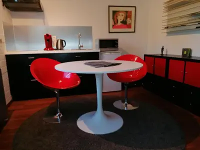 a kitchen with a white table and two red chairs at Studio's Park - Heverlee in Leuven