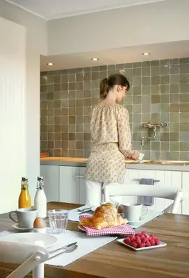 a woman standing at a counter in a kitchen at midiSud Apartment in Ghent