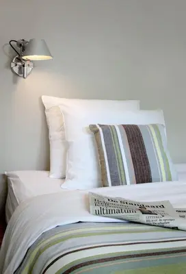 a bed with white pillows and a book on it at midiSud Apartment in Ghent