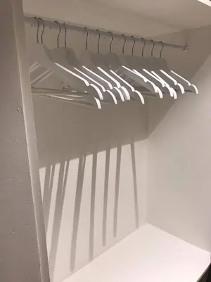 a shelf in a closet with a rack of clothes at Your suite Ghent in Ghent