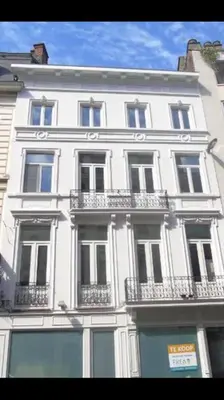 a large white building with balconies on a city street at Your suite Ghent in Ghent