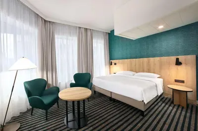 a hotel room with a bed and a table and chairs at Radisson Hotel Brussels Centre Midi in Brussels