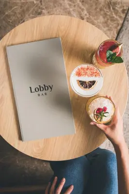 a person sitting at a table with a book and food at Radisson Hotel Brussels Centre Midi in Brussels