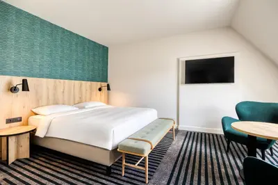a hotel room with a bed and a table and a chair at Radisson Hotel Brussels Centre Midi in Brussels