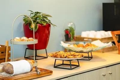 a table with three plates of bread and pastries at Radisson Hotel Brussels Centre Midi in Brussels