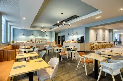 a restaurant with wooden tables and chairs at Radisson Hotel Brussels Centre Midi in Brussels