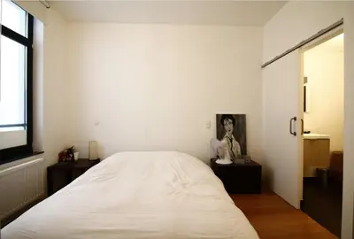 a bedroom with a large white bed and a window at Les Pieds a La Grande Place in Brussels