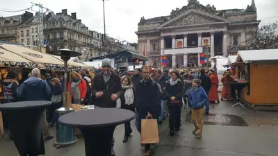 a crowd of people walking through a market in a city at Les Pieds a La Grande Place in Brussels