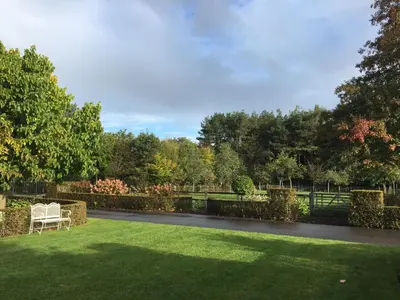 a garden with a bench in the grass at LOGIES Tuin der Zinnen in Rijkevorsel