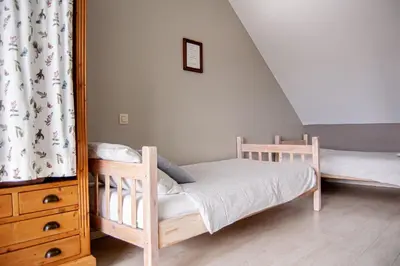 a bedroom with two bunk beds and a dresser at LOGIES Tuin der Zinnen in Rijkevorsel