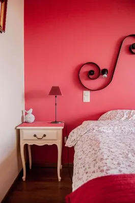 a red bedroom with a bed and a table with a lamp at LOGIES Tuin der Zinnen in Rijkevorsel
