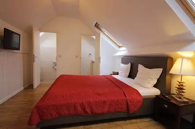 a bedroom with a large bed with a red blanket at B&B Le Lys d'or in Brussels