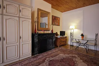 a living room with a table and a mirror at B&B Le Lys d'or in Brussels