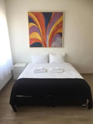 a bedroom with a large bed with a painting on the wall at Albert gare du Midi , 29 in Brussels