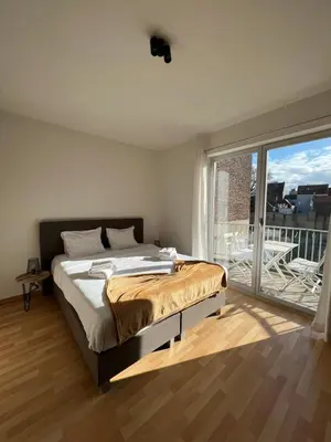 a bedroom with a bed and a large window at Antwerp City Appartment in Antwerp