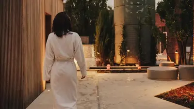 a woman walking down a sidewalk in a building at Aspria Royal La Rasante Hotel & Spa in Brussels