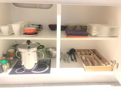 a cupboard with a blender and plates and utensils at Les lofts de Styliste in Brussels