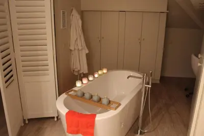 a bathroom with a tub with candles in it at Mille Étoiles in Moorsel