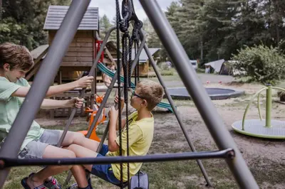 three young boys playing on a playground at Camping Siesta in Lille