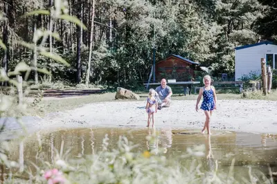 a man and two children standing in the water at Camping Siesta in Lille