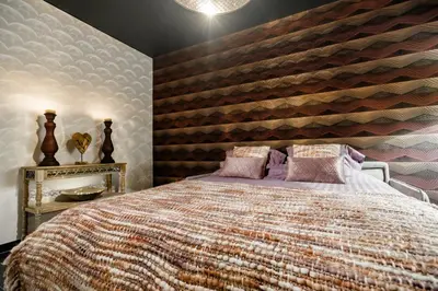 a bedroom with a large bed with a wooden wall at Casa Lavanda in Zottegem