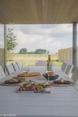 a table with two glasses of wine and food on it at Casa Lavanda in Zottegem