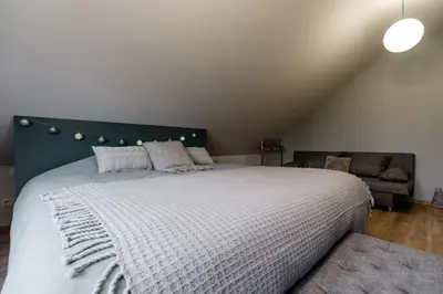 a bedroom with a large bed and a couch at Casa Lavanda in Zottegem