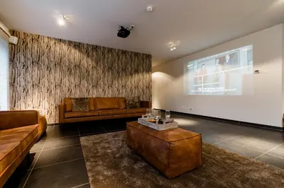a living room with a couch and a large screen at Casa Lavanda in Zottegem