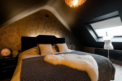 a bedroom with a large bed with a window at Casa Lavanda in Zottegem