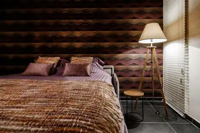 a bedroom with a bed and a striped wall at Casa Lavanda in Zottegem
