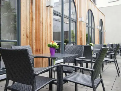 a row of chairs and tables on a patio at Novotel Brussels Centre Midi in Brussels