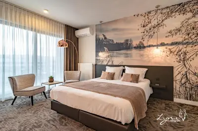 a bedroom with a large bed and a large painting on the wall at De Vesten Comfort Lodge in Laakdal
