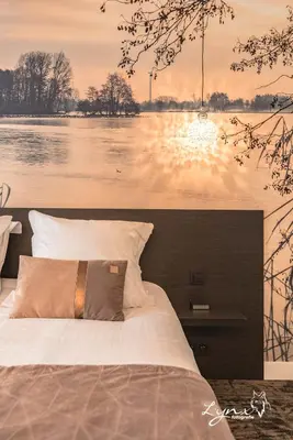 a bedroom with a large bed with a view of a lake at De Vesten Comfort Lodge in Laakdal