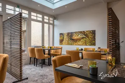 a dining room with tables and chairs and a painting on the wall at De Vesten Comfort Lodge in Laakdal