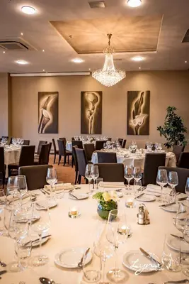 a conference room with tables and chairs and a chandelier at De Vesten Comfort Lodge in Laakdal