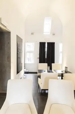 a waiting room with white chairs and tables at Zimmerhof Hotel in Lier