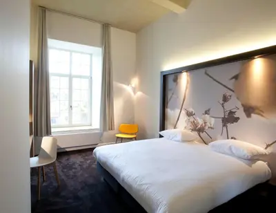 a hotel room with a large bed and a window at Hotel The Lodge Vilvoorde in Vilvoorde