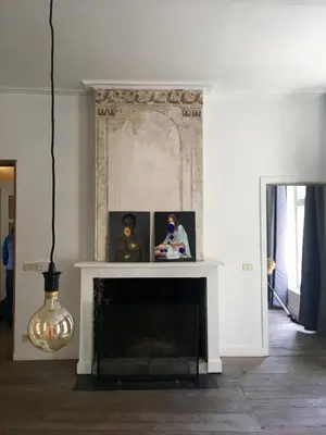 a living room with a fireplace and a chandelier at Huize Maeterlinck in Ghent