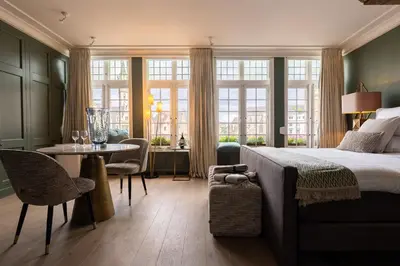 a bedroom with a bed and a table and chairs at Rooms With A View in Ghent