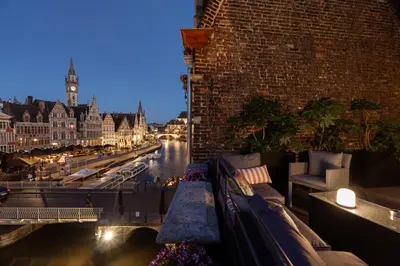 a balcony with a view of a river at night at Rooms With A View in Ghent